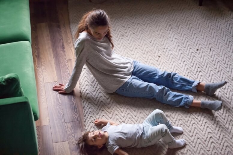 Moeder en kind spelen op de vloer